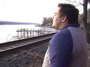 Kaleb Marschalk gazes out at the sunset from his yard on Cayuga Lake's east shore.